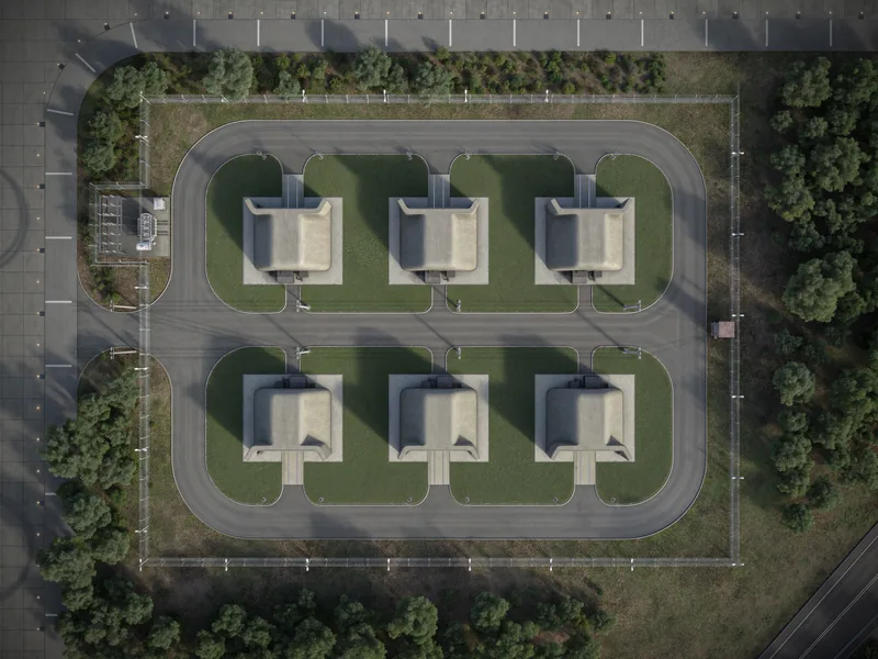 Aerial view of six concrete enclosures inside a fenced compound, rendered in 3D